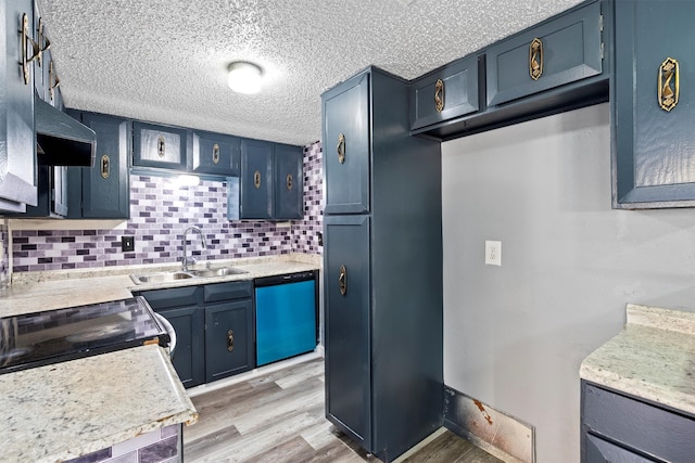 kitchen featuring sink, tasteful backsplash, blue cabinetry, light wood-type flooring, and dishwasher