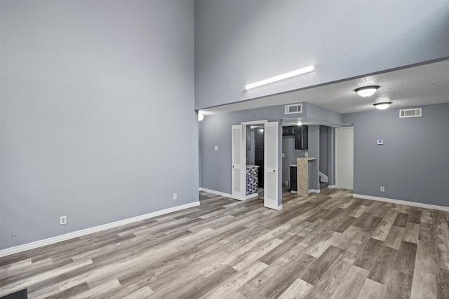 unfurnished living room with hardwood / wood-style floors and a textured ceiling