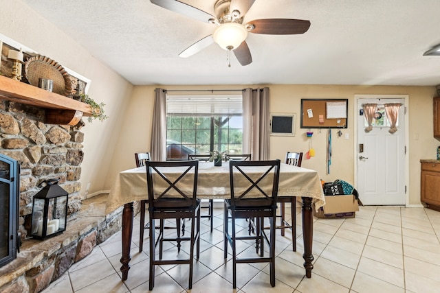 tiled dining room with a textured ceiling and ceiling fan