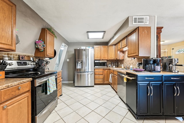 kitchen with appliances with stainless steel finishes, light tile patterned flooring, tasteful backsplash, and sink