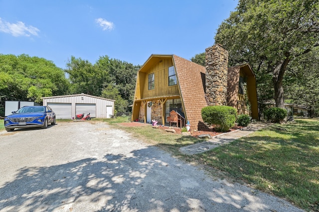 view of front of home featuring a front yard, an outdoor structure, and a garage