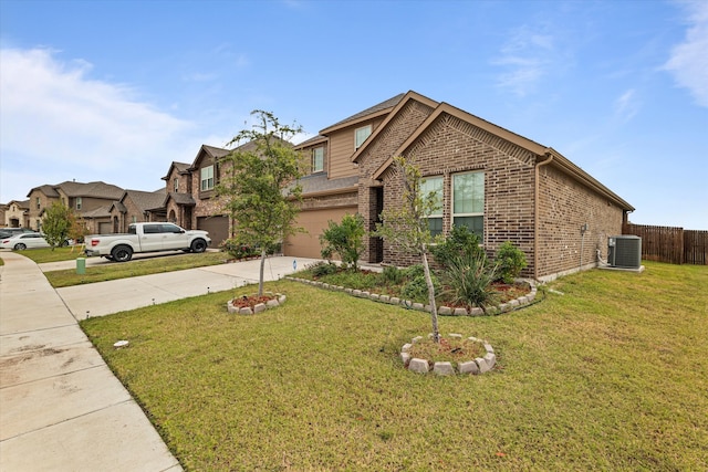 view of front of home with a front yard, a garage, and central AC unit