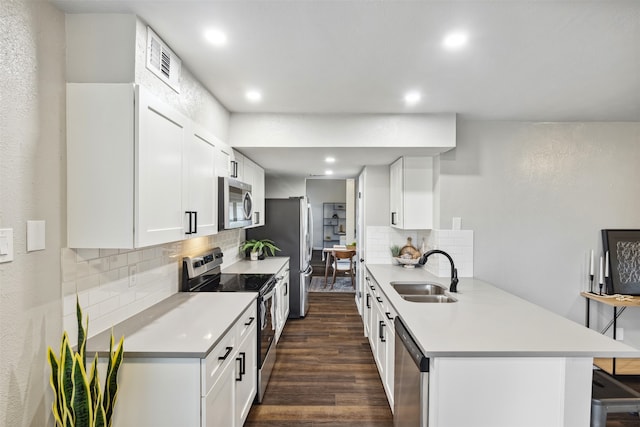 kitchen with sink, a kitchen breakfast bar, dark hardwood / wood-style flooring, white cabinets, and appliances with stainless steel finishes