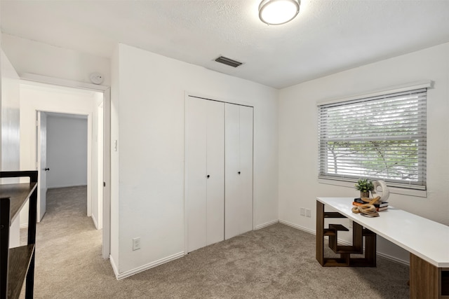 carpeted home office with a textured ceiling