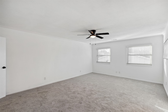 carpeted spare room with ceiling fan and crown molding