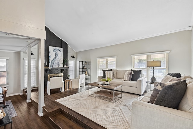 living room featuring hardwood / wood-style floors, ornamental molding, high vaulted ceiling, and a brick fireplace