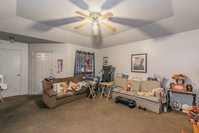 living room with ceiling fan, a textured ceiling, a raised ceiling, and carpet floors