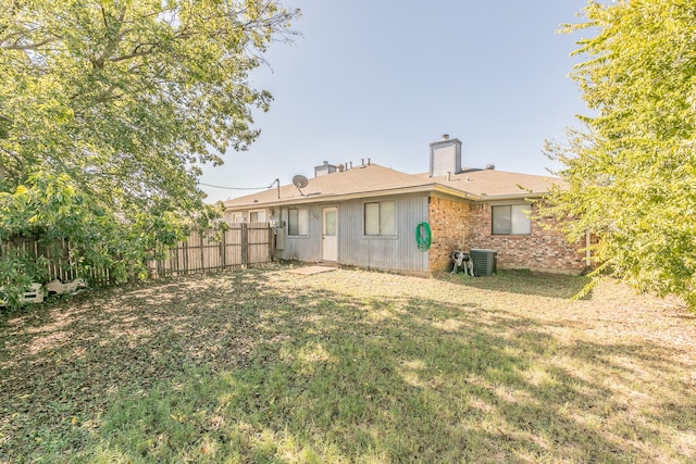 back of property featuring cooling unit and a yard