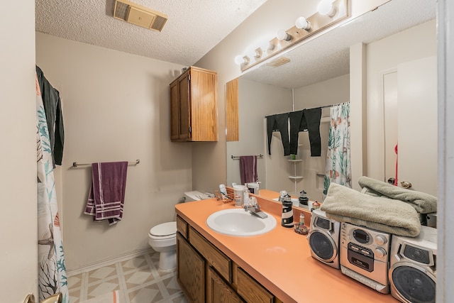 bathroom featuring vanity, a textured ceiling, and toilet