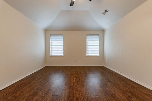 spare room with ceiling fan, vaulted ceiling, and dark hardwood / wood-style floors