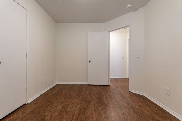 unfurnished room with dark hardwood / wood-style floors