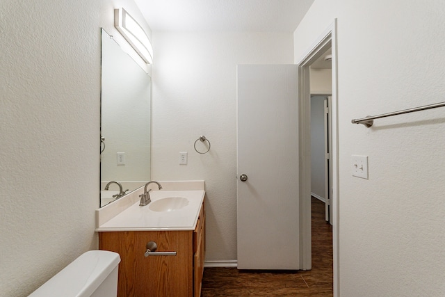 bathroom featuring toilet, hardwood / wood-style flooring, and vanity