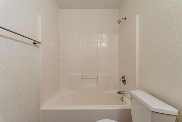 bathroom featuring tiled shower / bath and toilet