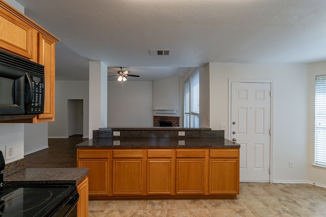 kitchen with black appliances, dark stone counters, a textured ceiling, and ceiling fan