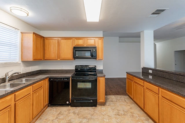 kitchen with sink, black appliances, and light wood-type flooring