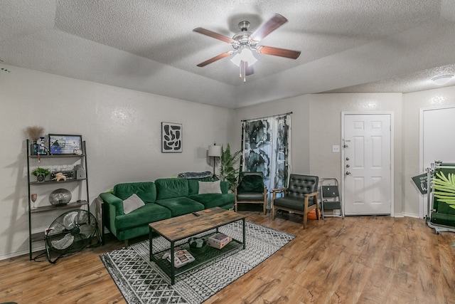 living room featuring hardwood / wood-style flooring, a textured ceiling, and ceiling fan