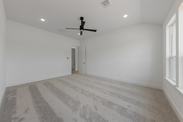 spare room featuring ceiling fan, light carpet, and lofted ceiling