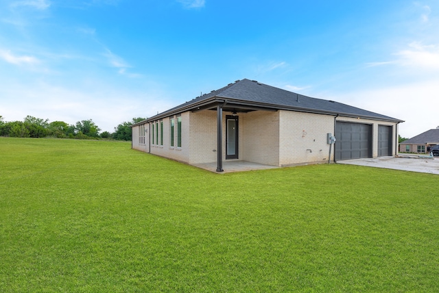 rear view of house with a lawn and a garage