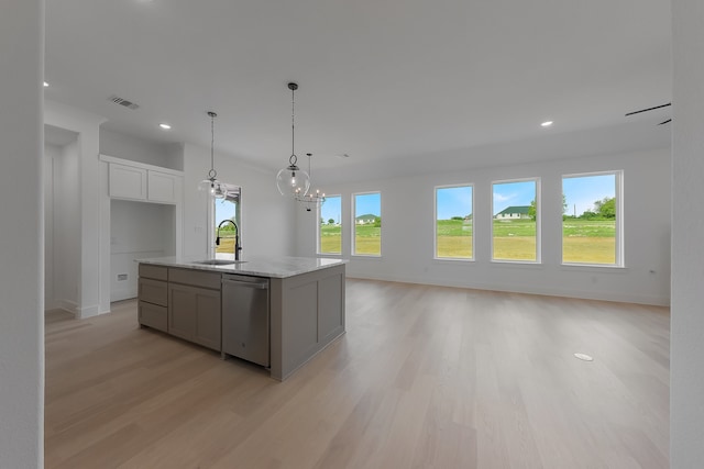 kitchen with sink, light wood-type flooring, stainless steel dishwasher, white cabinets, and a kitchen island with sink