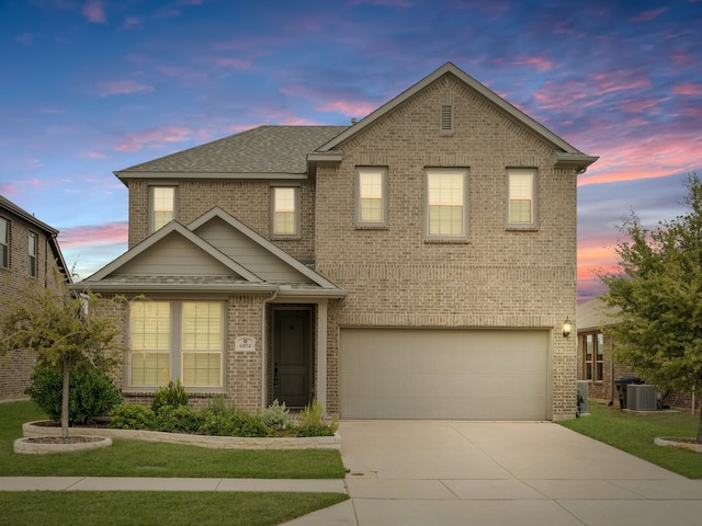 view of front of home featuring a yard, cooling unit, and a garage