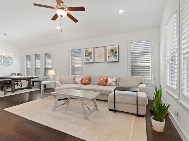 living room featuring lofted ceiling, ceiling fan with notable chandelier, and light hardwood / wood-style floors