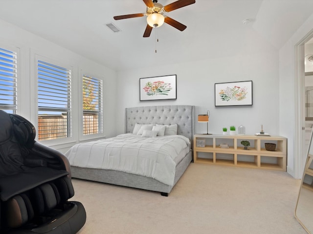 carpeted bedroom with ceiling fan, ensuite bathroom, and vaulted ceiling