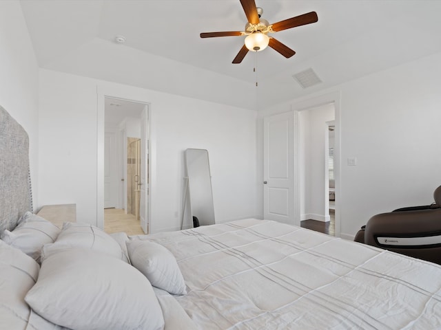 bedroom with ceiling fan and a tray ceiling