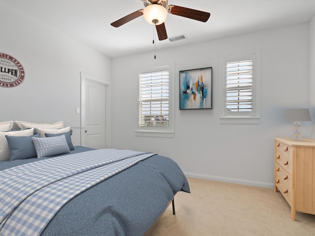 bedroom with ceiling fan, light carpet, and multiple windows