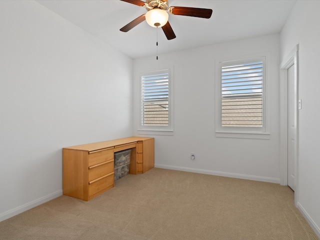 unfurnished office with ceiling fan and light colored carpet