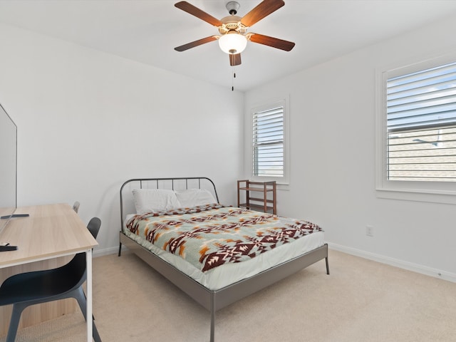 carpeted bedroom featuring multiple windows and ceiling fan