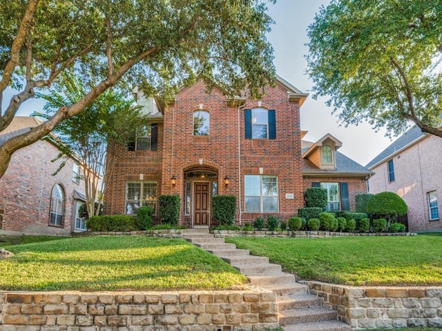 view of front facade with brick siding and a front lawn