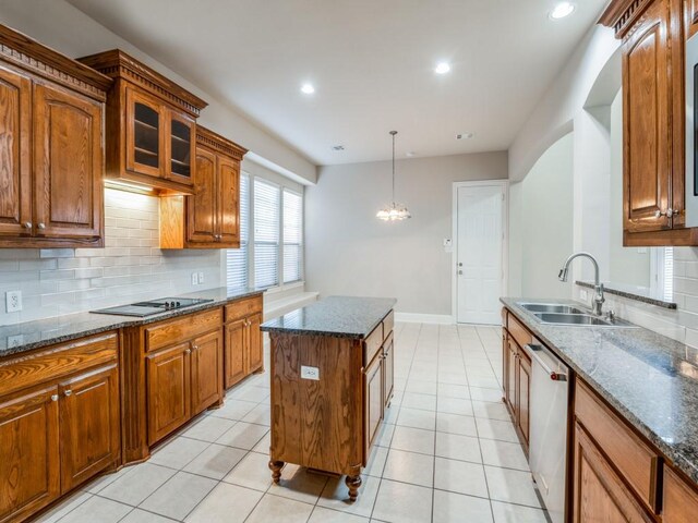 kitchen with stainless steel dishwasher, sink, decorative backsplash, and a kitchen island