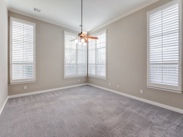 carpeted spare room with crown molding, ceiling fan, and plenty of natural light