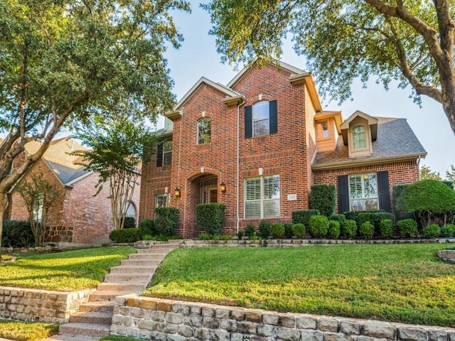 traditional-style house with brick siding and a front lawn