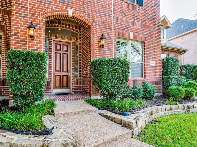 view of exterior entry with brick siding