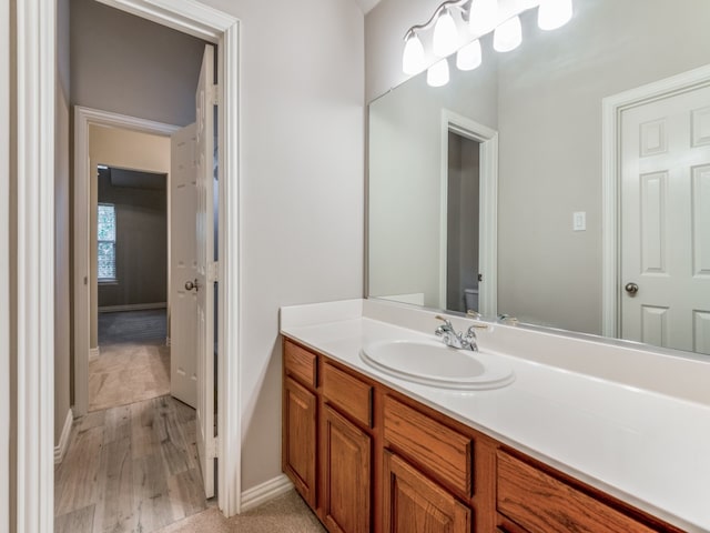 bathroom with vanity, toilet, and hardwood / wood-style flooring