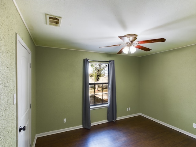 empty room with ceiling fan and dark hardwood / wood-style flooring