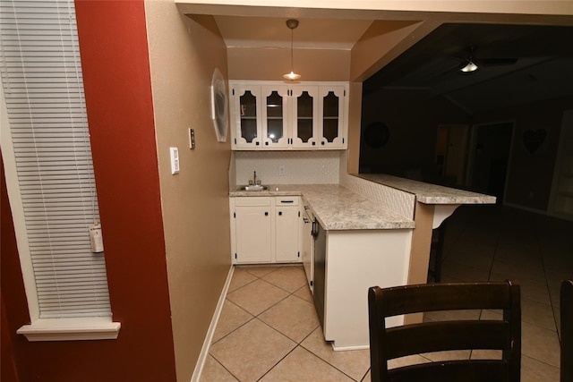 kitchen with sink, pendant lighting, white cabinets, light stone counters, and light tile patterned floors