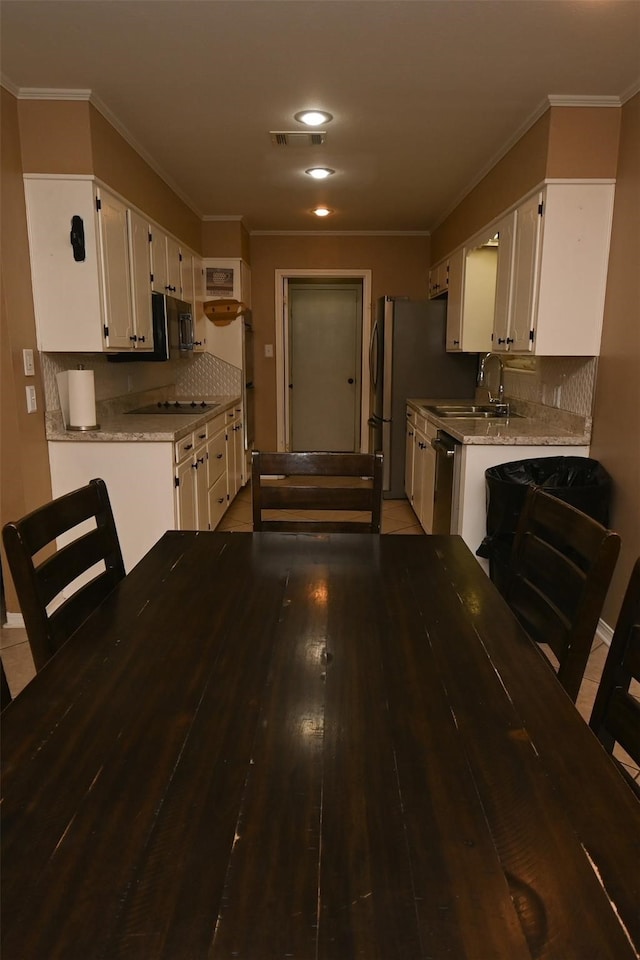 kitchen featuring backsplash, sink, crown molding, stainless steel dishwasher, and white cabinets