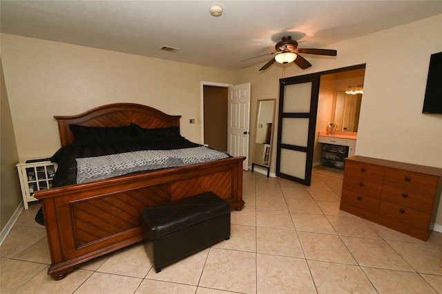 tiled bedroom featuring ensuite bath and ceiling fan