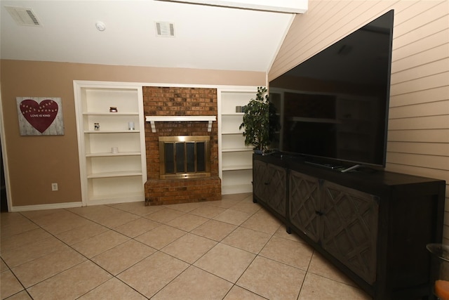 unfurnished living room with lofted ceiling, a brick fireplace, built in shelves, and light tile patterned floors