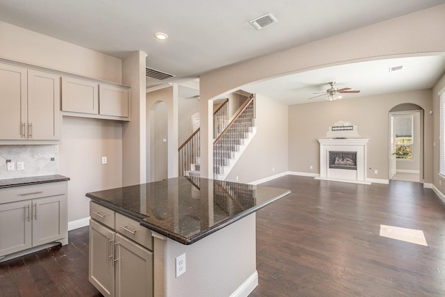 kitchen with dishwasher, sink, dark hardwood / wood-style floors, and dark stone counters