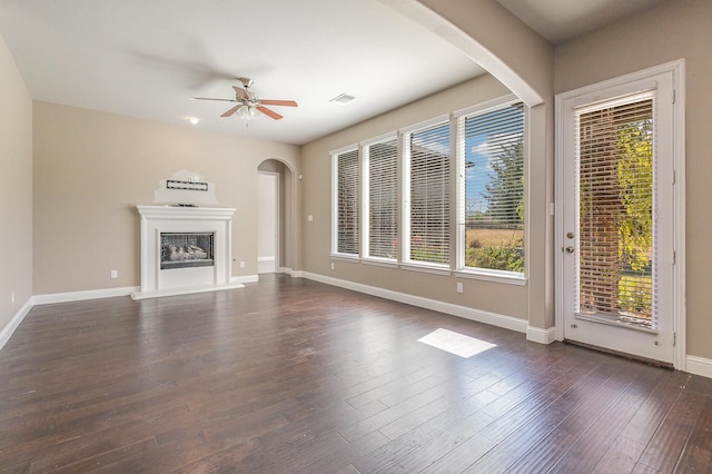 unfurnished living room featuring crown molding, dark hardwood / wood-style floors, and ceiling fan