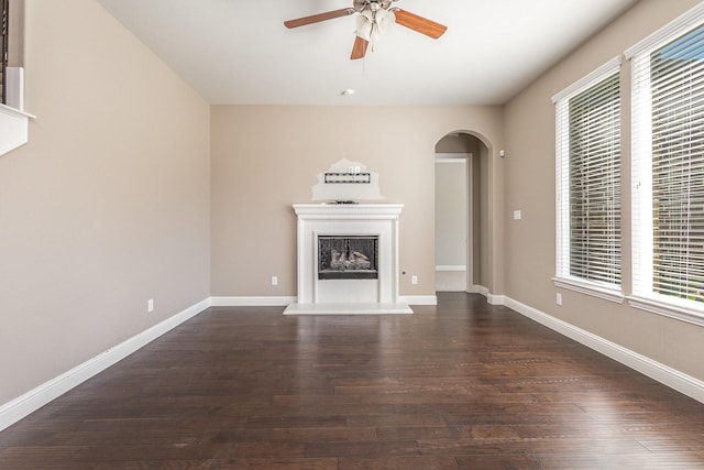 unfurnished living room featuring ceiling fan and dark hardwood / wood-style flooring