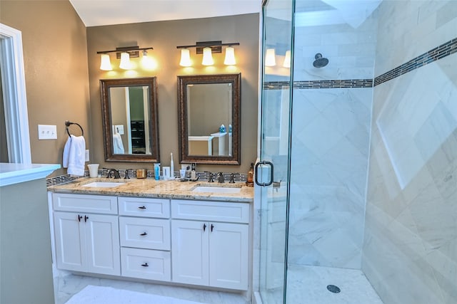 bathroom featuring a shower with door and vanity