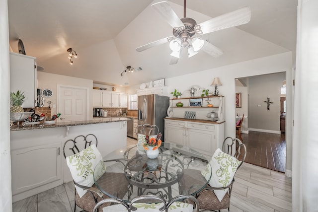 dining space with lofted ceiling, light wood-type flooring, and ceiling fan