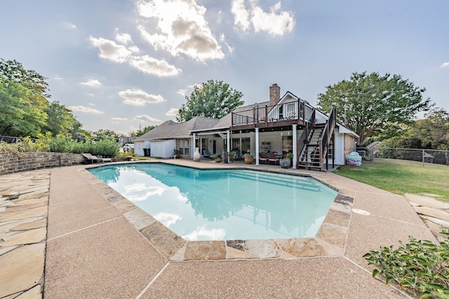 view of pool with a wooden deck and a patio