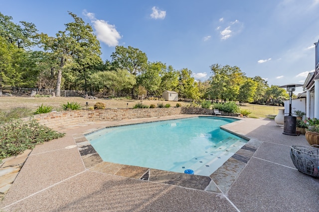 view of pool featuring a shed and a patio area