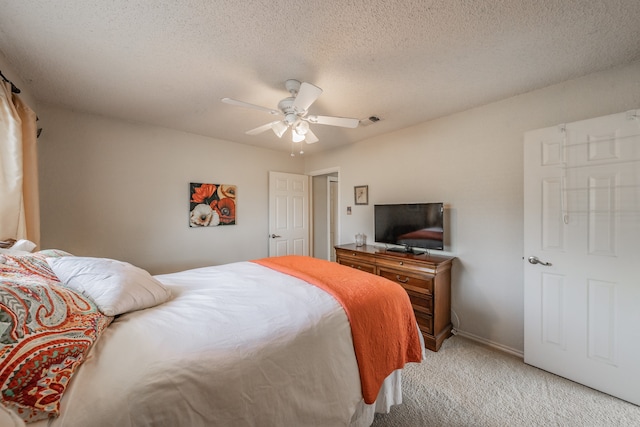 carpeted bedroom with a textured ceiling and ceiling fan