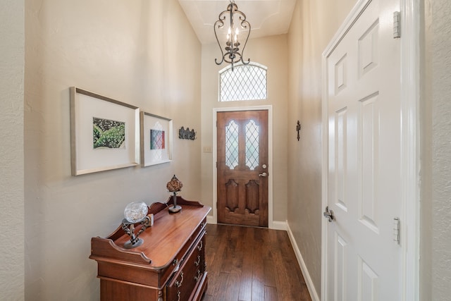 doorway to outside with a chandelier and dark hardwood / wood-style flooring